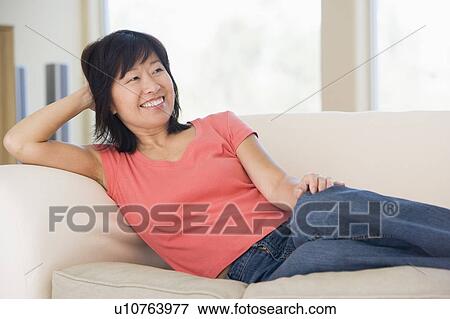 Woman relaxing in living room smiling View Large Photo Image Stock Photo - Woman relaxing in living room smiling. Fotosearch