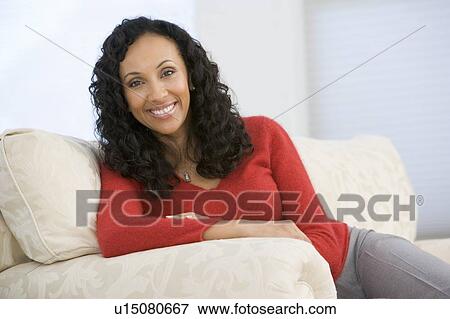 Woman sitting in living room View Large Photo Image Stock Photo - Woman sitting in living room. Fotosearch