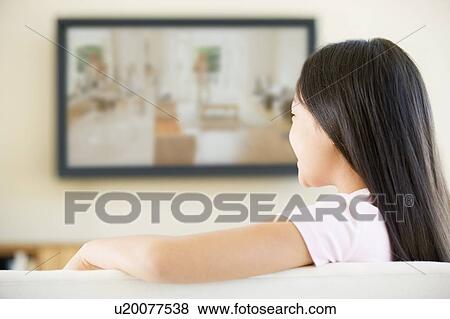 Young girl in living room with flat screen television View Large Photo Image Stock Photo - Young girl in living room with flat screen television. Fotosearch