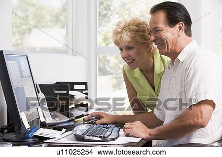 Couple in home office at computer smiling View Large Photo Image Picture - Couple in home office at computer smiling. Fotosearch