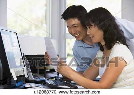 Couple in home office with computer and paperwork smiling View Large Photo Image Stock Image - Couple in home office with computer and paperwork smiling. Fotosearch