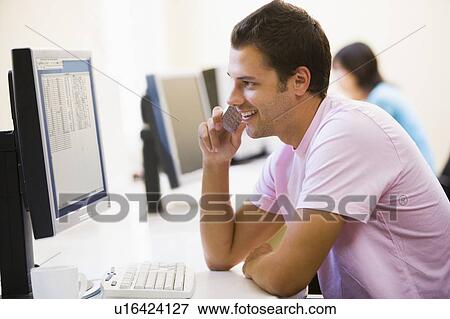 Man in computer room using cellular phone and smiling View Large Photo Image Stock Photo - Man in computer room using cellular phone and smiling. Fotosearch