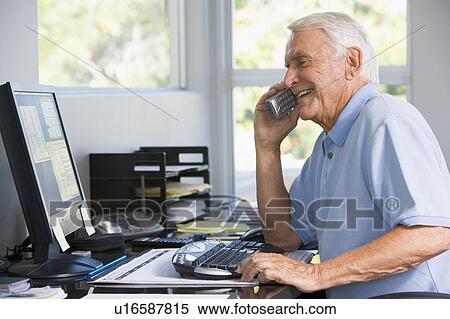 Man in home office on telephone using computer smiling View Large Photo Image Stock Photography - Man in home office on telephone using computer smiling. Fotosearch