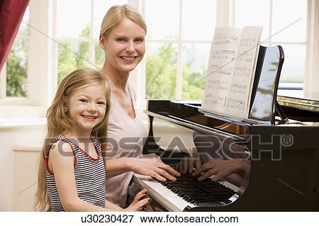 Woman and young girl playing piano and smiling View Large Photo Image Stock Photo - Woman and young girl playing piano and smiling. Fotosearch
