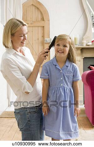 Woman in front hallway brushing young girl's hair and smiling View Large Photo Image Stock Photography - Woman in front hallway brushing young girl's hair and smiling. Fotosearch
