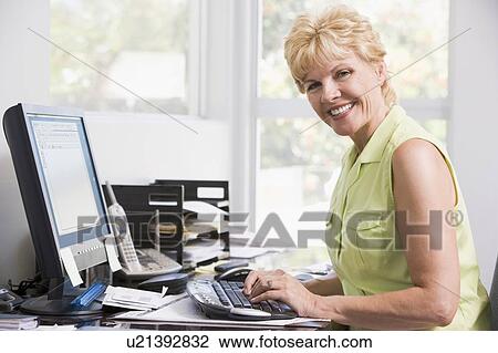 Woman in home office at computer smiling View Large Photo Image Stock Image - Woman in home office at computer smiling. Fotosearch