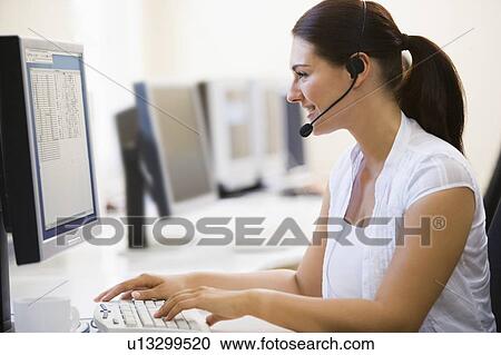Woman wearing headset in computer room smiling View Large Photo Image Stock Image - Woman wearing headset in computer room smiling. Fotosearch
