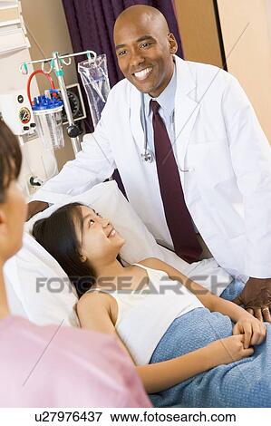 Stock Photo - Doctor And Patient Smiling In Hospital Room. Fotosearch