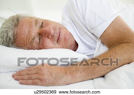 Man lying in bed sleeping View Large Photo Image Stock Photo - Man lying in bed sleeping. Fotosearch