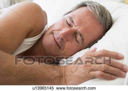 Stock Photography - Man lying in bed sleeping. Fotosearch