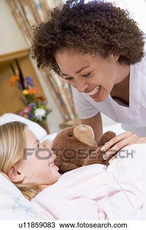 Stock Image - Nurse Laughing With Her Young Patient. Fotosearch