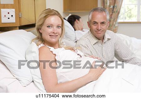 Pregnant woman with husband in hospital smiling View Large Photo Image Picture - Pregnant woman with husband in hospital smiling. Fotosearch