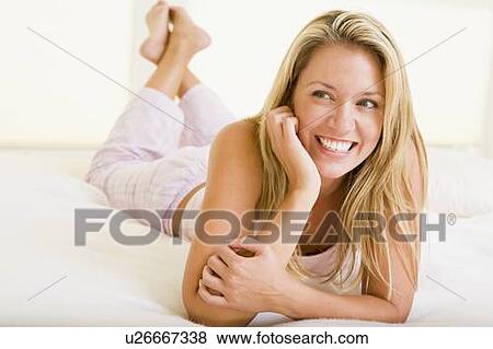 Woman lying in bedroom smiling View Large Photo Image Stock Photo - Woman lying in bedroom smiling. Fotosearch