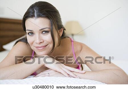 Woman relaxing on bed in bedroom smiling (selective focus) View Large Photo Image Stock Image - Woman relaxing on bed in bedroom smiling (selective focus). Fotosearch