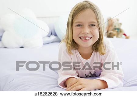 Stock Photo - Young Girl Lying On Her Bed In Her Pajamas. Fotosearch
