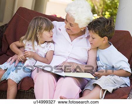 Stock Photo - Grandmother reading to grandchildren.. Fotosearch