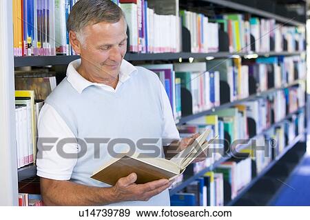 Man in library reading book (depth of field) View Large Photo Image Stock Photo - Man in library reading book (depth of field). Fotosearch