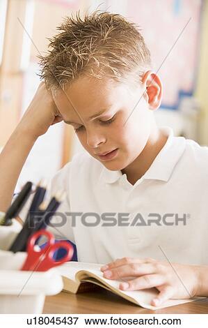 Student in class reading book View Large Photo Image Stock Photo - Student in class reading book. Fotosearch