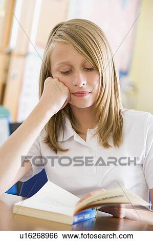Stock Photograph - Student in class reading book. Fotosearch