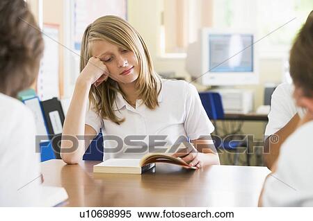 Stock Photography - Student in class reading book. Fotosearch