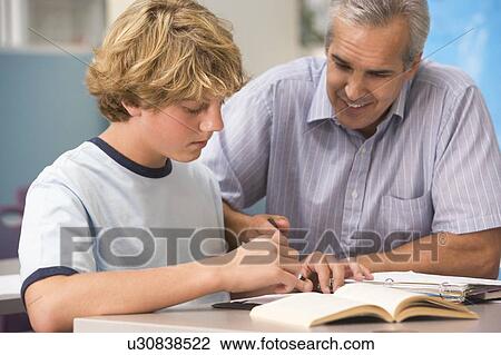 Teacher giving personal instruction to male student View Large Photo Image Stock Image - Teacher giving personal instruction to male student. Fotosearch