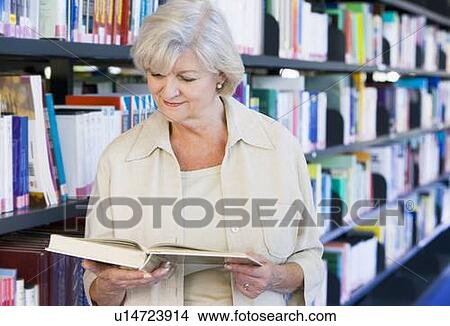 Picture - Woman in library reading book (depth of field). Fotosearch