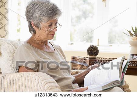 Woman in living room reading book View Large Photo Image Stock Image - Woman in living room reading book. Fotosearch