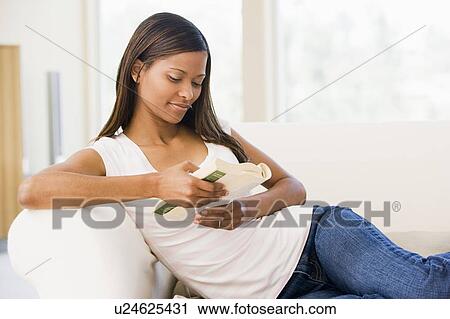 Woman in living room reading book View Large Photo Image Stock Image - Woman in living room reading book. Fotosearch