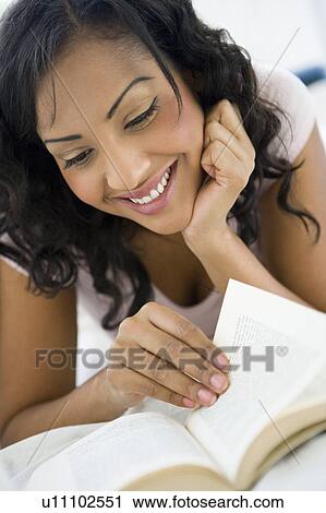 Woman in living room with book smiling (high key/selective focus) View Large Photo Image Stock Image - Woman in living room with book smiling (high key/selective focus). Fotosearch