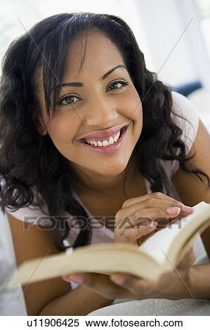 Woman in living room with book smiling (high key/selective focus) View Large Photo Image Stock Photography - Woman in living room with book smiling (high key/selective focus). Fotosearch