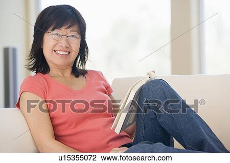 Woman relaxing with a book and smiling View Large Photo Image Stock Image - Woman relaxing with a book and smiling. Fotosearch