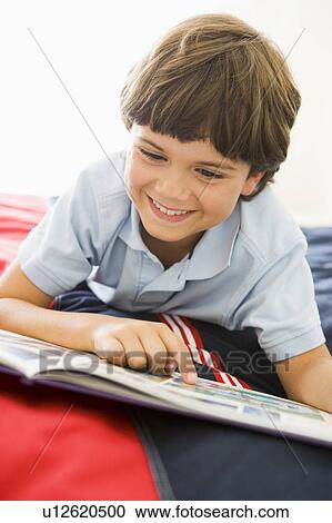 Young Boy Lying Down On His Bed Reading A Book View Large Photo Image Stock Image - Young Boy Lying Down On His Bed Reading A Book. Fotosearch