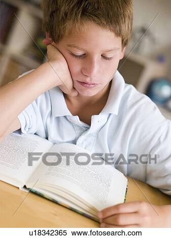 Stock Photography - Young Boy Reading A Book In His Room. Fotosearch