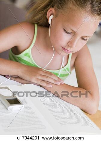 Young Girl Reading A Book While Listening To An MP3 Player View Large Photo Image Stock Image - Young Girl Reading A Book While Listening To An MP3 Player. Fotosearch