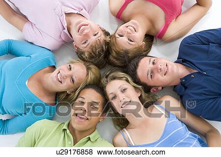 Stock Photo - Teenagers Lying Down Head To Head. Fotosearch