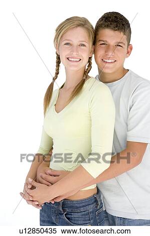 Young couple standing together smiling View Large Photo Image Stock Photography - Young couple standing together smiling. Fotosearch