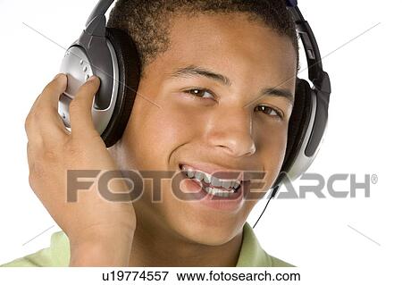 Stock Photo - Teenage Boy Listening To Music On Headphones. Fotosearch