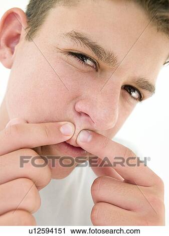 Teenage boy popping zit on face View Large Photo Image Stock Image - Teenage boy popping zit on face. Fotosearch