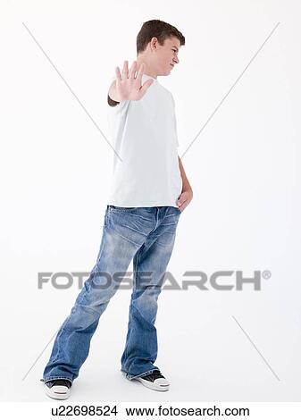 Picture - Teenage boy standing with hand up. Fotosearch