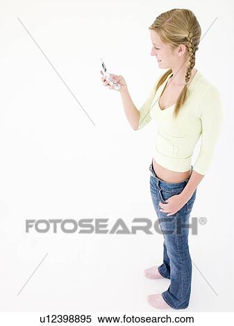 Stock Photography - Teenage girl holding cellular phone and smiling. Fotosearch