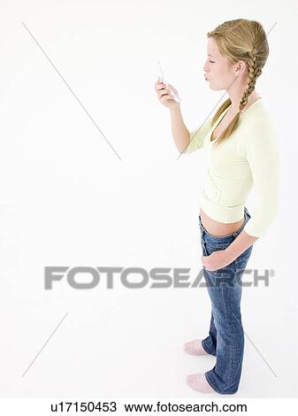 Teenage girl looking at cellular phone and puckering up View Large Photo Image Stock Image - Teenage girl looking at cellular phone and puckering up. Fotosearch