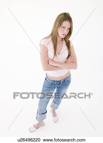 Stock Image - Teenage girl with arms crossed frowning. Fotosearch