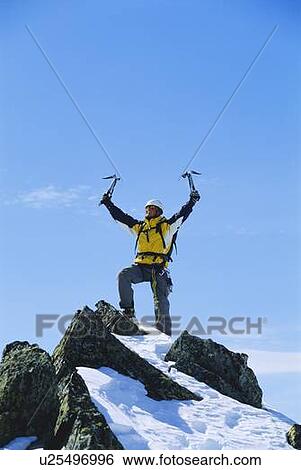 Mountain climber standing on snowy mountain victorious and smiling View Large Photo Image Stock Photograph - Mountain climber standing on snowy mountain victorious and smiling. Fotosearch