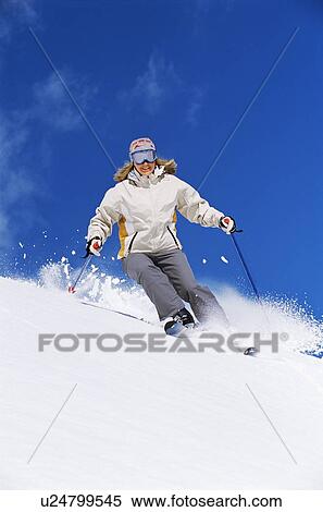 Stock Photography - Skier coming down hill smiling. Fotosearch