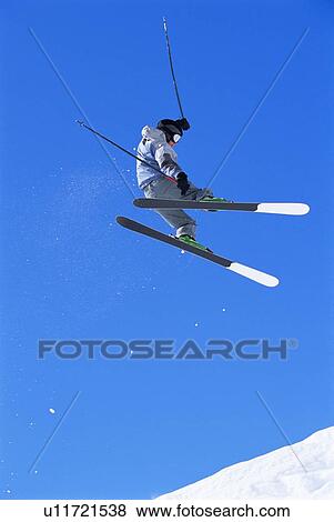 Skier doing jump on snowy hill View Large Photo Image Stock Photo - Skier doing jump on snowy hill. Fotosearch