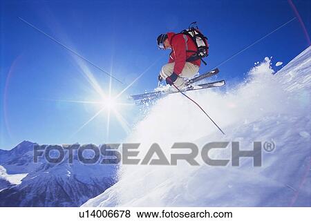 Stock Photo - Skier jumping on snowy hill (lens flare). Fotosearch
