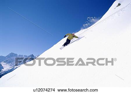 Snowboarder coming down snowy hill View Large Photo Image Picture - Snowboarder coming down snowy hill. Fotosearch