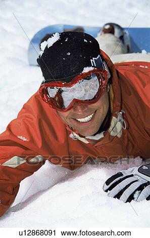Snowboarder lying on hill smiling (selective focus) View Large Photo Image Stock Image - Snowboarder lying on hill smiling (selective focus). Fotosearch