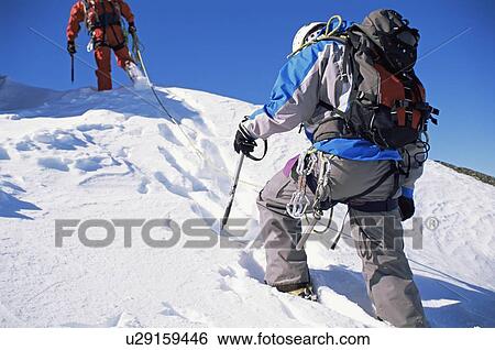 Two mountain climbers walking in snow (selective focus) View Large Photo Image Stock Photograph - Two mountain climbers walking in snow (selective focus). Fotosearch