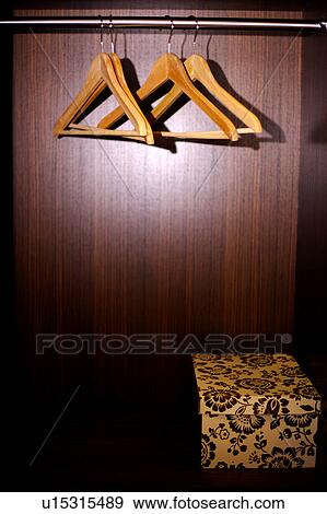 Stock Photo - Close-up of four clothes racks and a box in the closet. Fotosearch